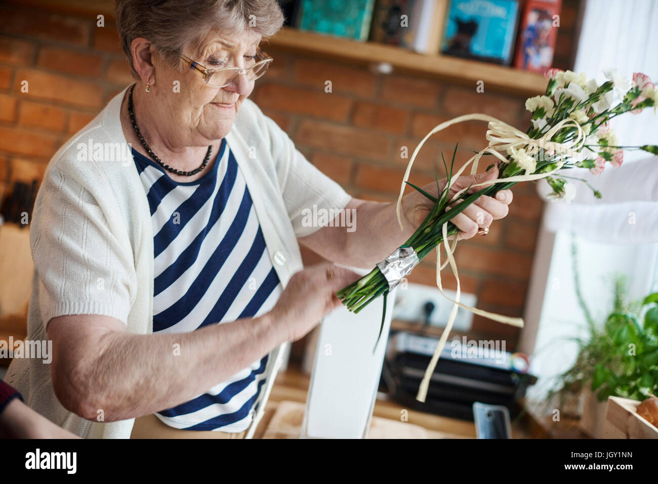 Senior adult woman with floral craftwork Stock Photo