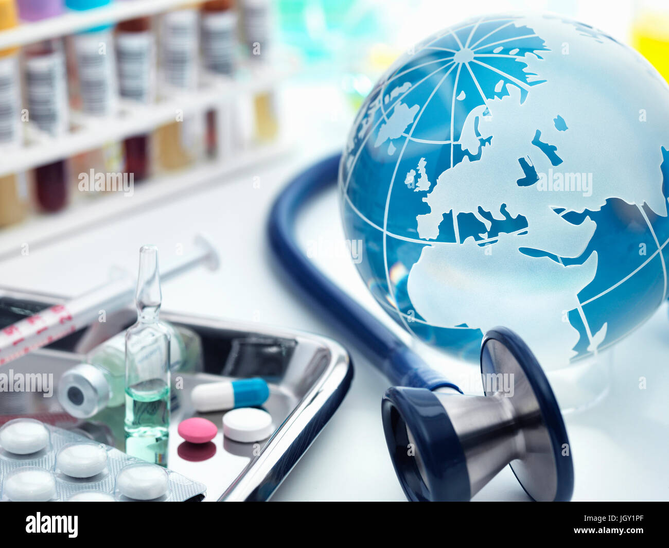 Globe with acoustic stethoscope and surgical tray with medicines Stock Photo