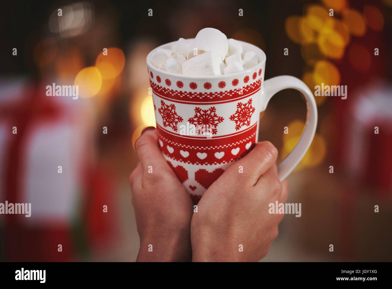 Woman holding hot chocolate in festive mug Stock Photo