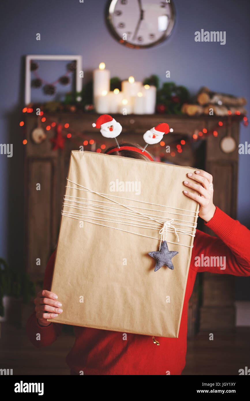 Woman holding christmas present in front of face Stock Photo - Alamy