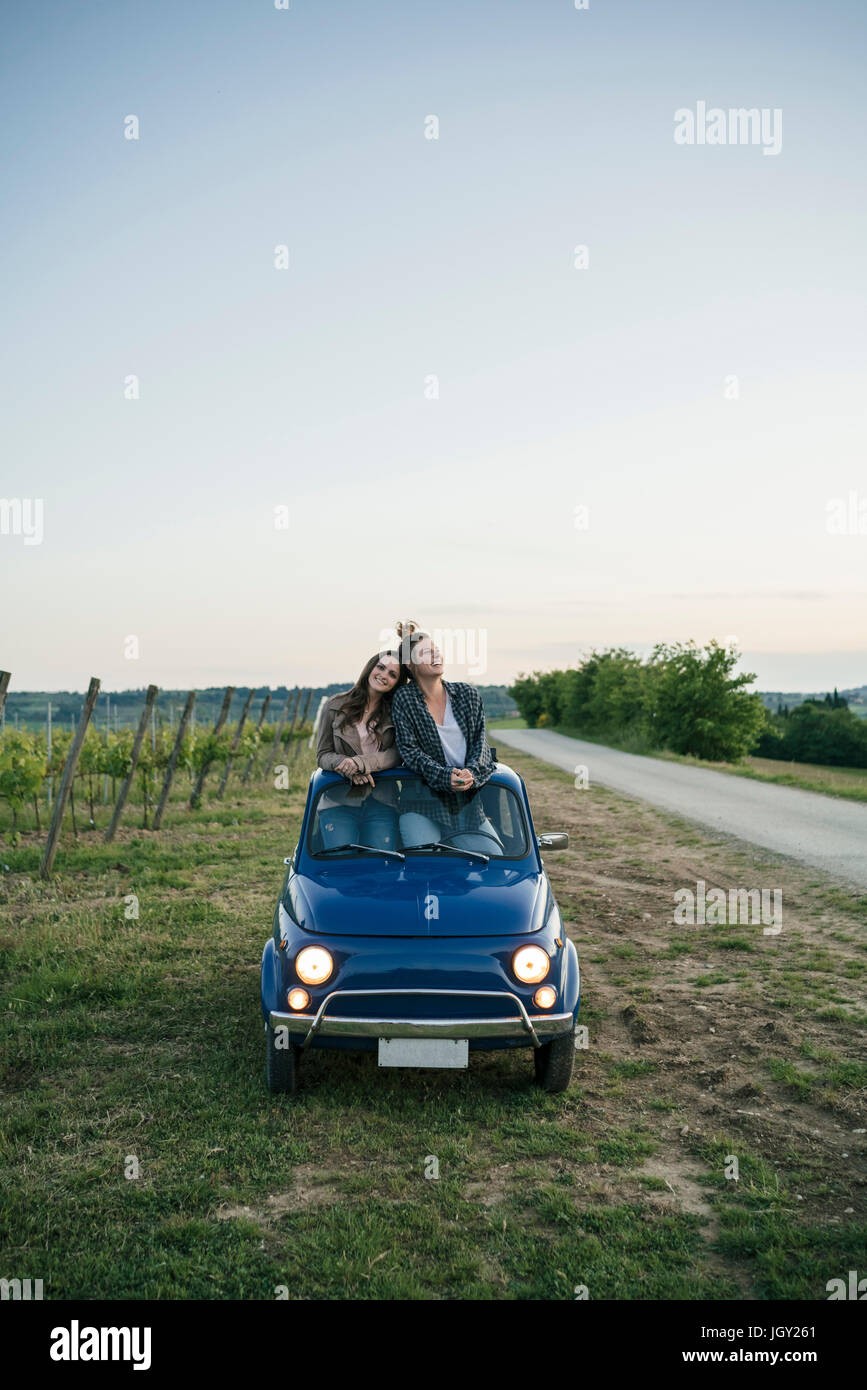 Tourists standing through car sunroof, vineyard, Tuscany, Italy Stock ...