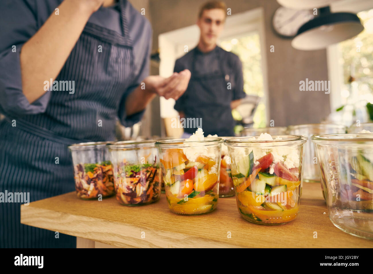 Chef filling plastic containers with portions of food Stock Photo