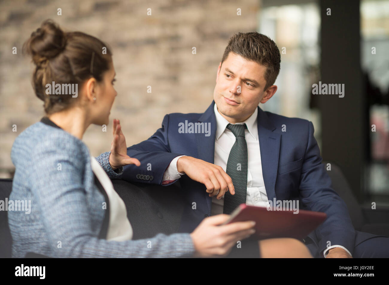 Businessman and woman meeting on office sofa Stock Photo - Alamy