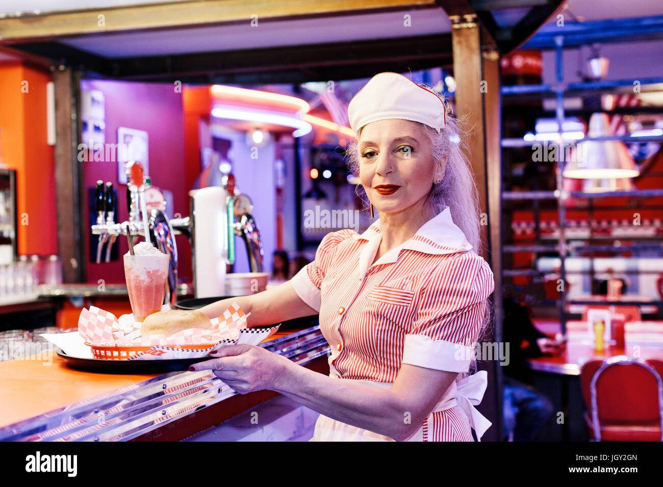 Portrait of mature female waitress in 1950's diner Stock Photo