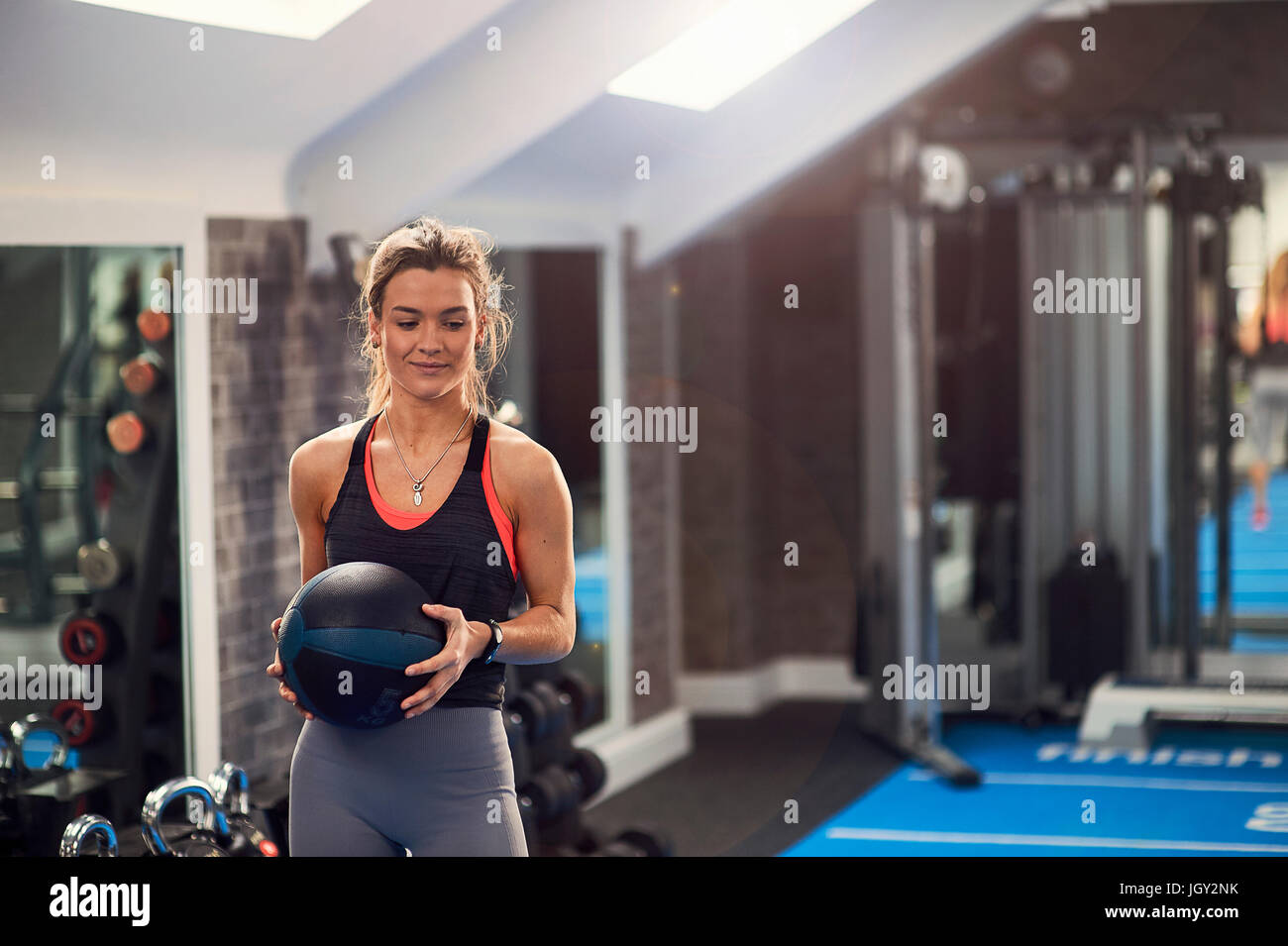 Young woman training, holding atlas ball in gym Stock Photo - Alamy