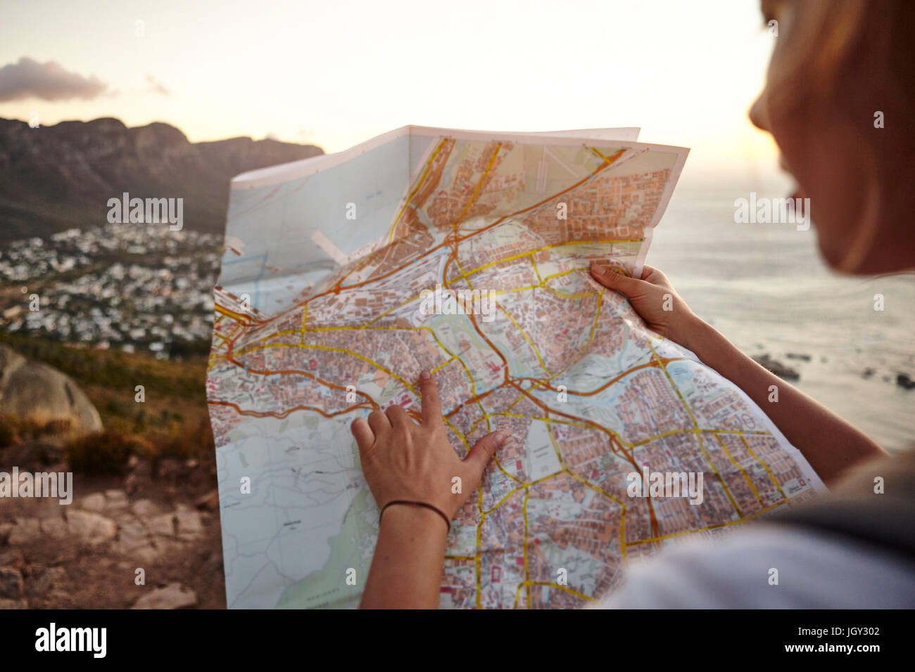 Young woman hiking, looking at map, Lions head Mountain, Western Cape, Cape Town, South Africa Stock Photo