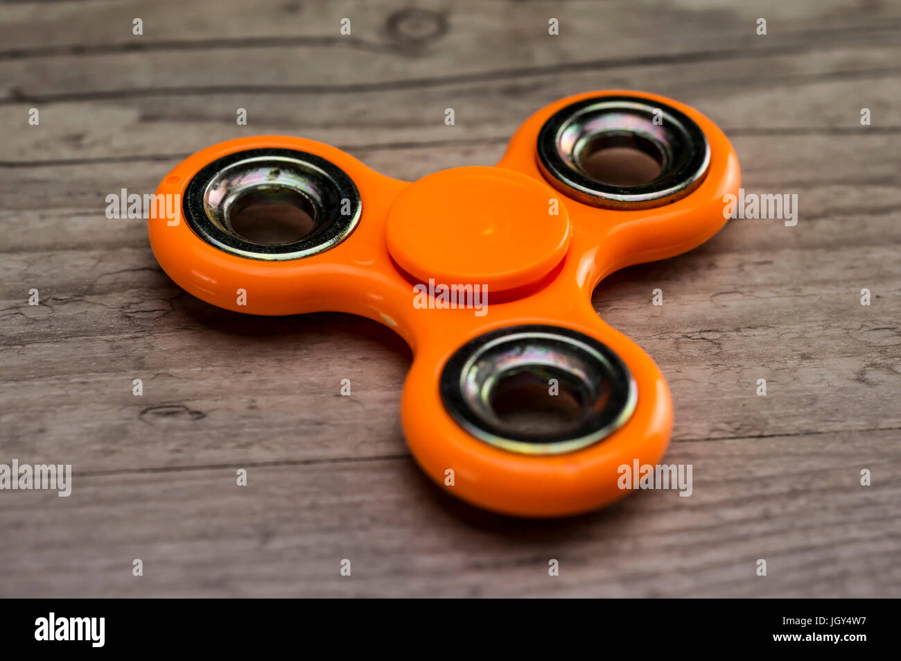 Close up shot of an orange fidget spinner Stock Photo - Alamy