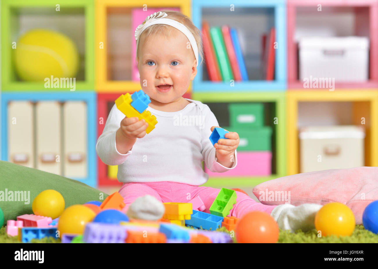 Adorable little child playing with colorful toys Stock Photo - Alamy