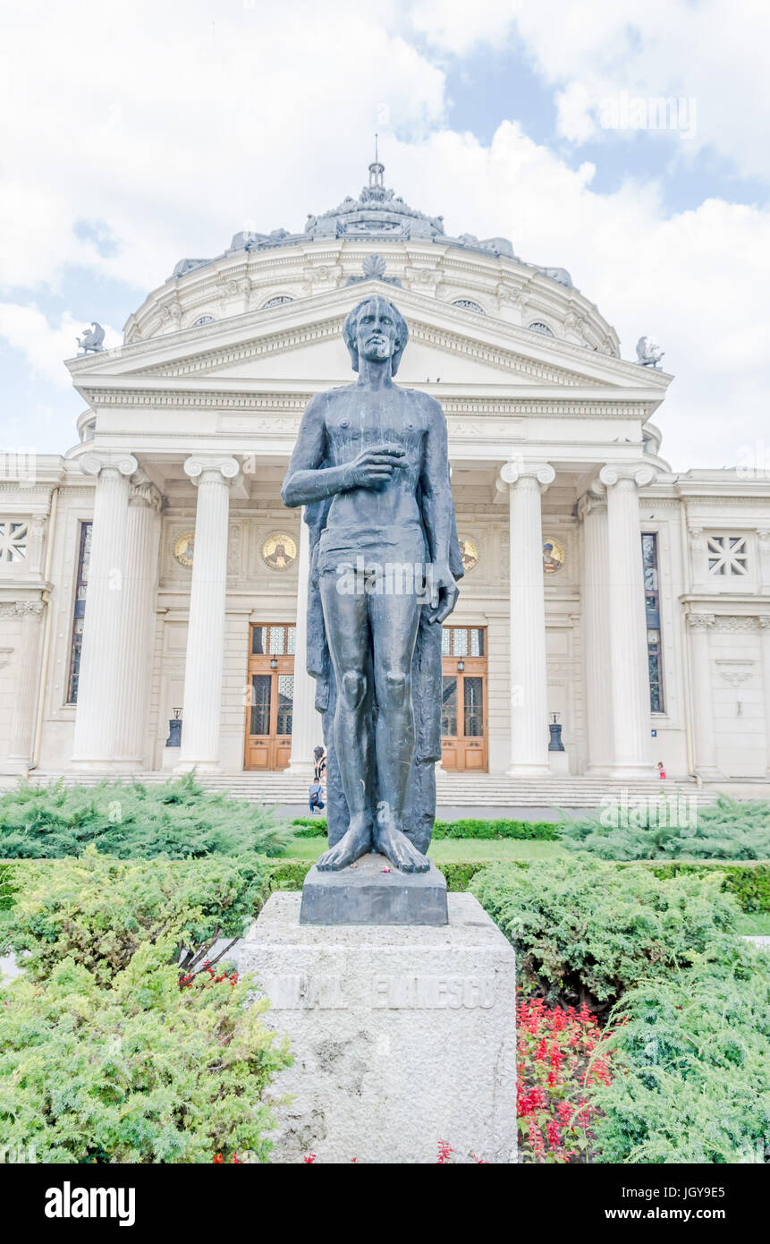 BUCHAREST, ROMANIA - MAY 25, 2014: The statue of Mihai Eminescu in front of the Building called 'Ateneul Roman'. Romanian Athenaeum. Stock Photo