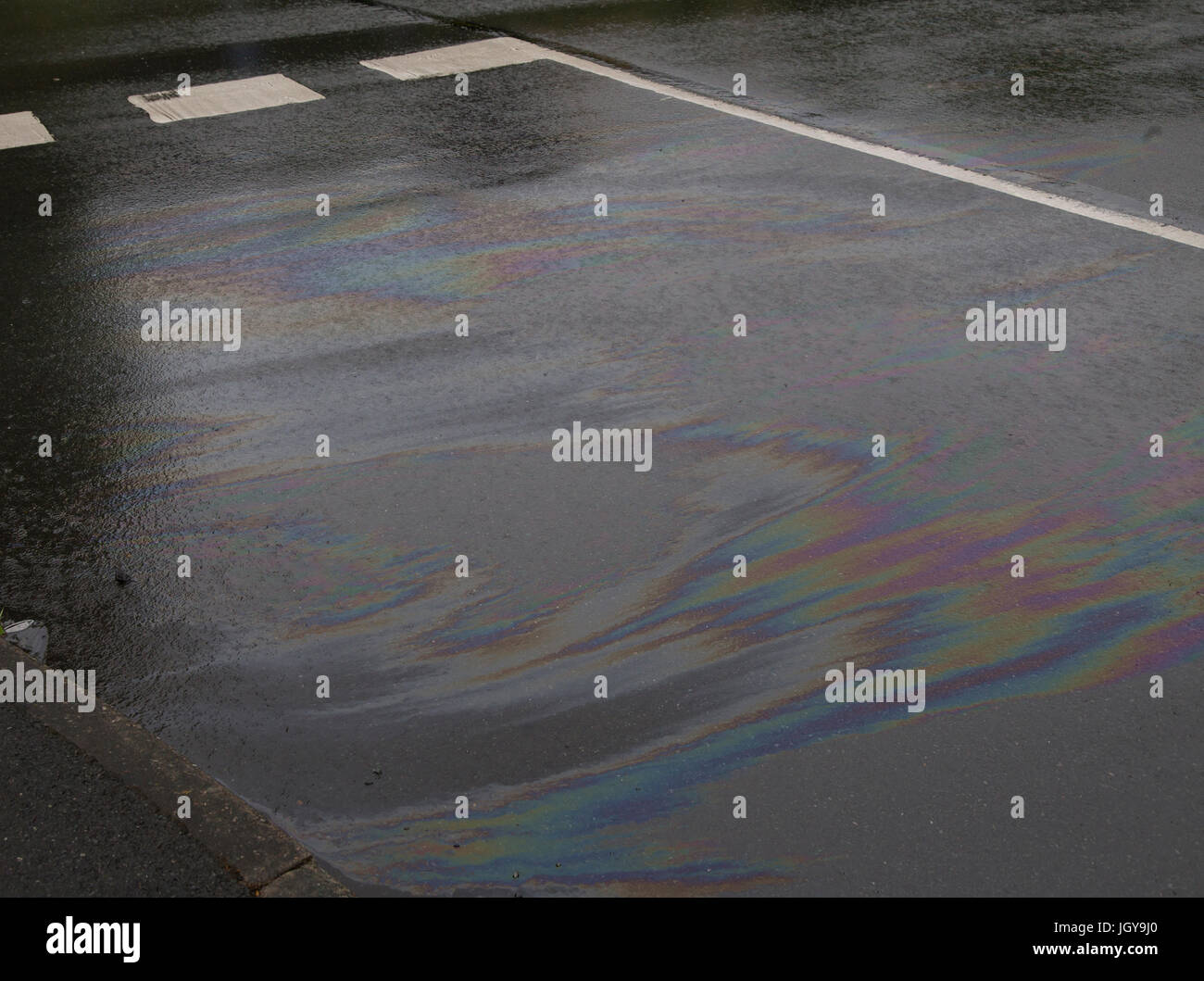 The coloured patterns produced by oil spillage on the road Stock Photo
