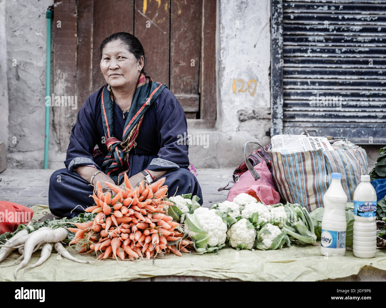 Leh, Ladakh, India, July 12, 2016: local woman is selling produce and milk on a sidewalk market in Leh, Ladakh district of Kashmir, India Stock Photo