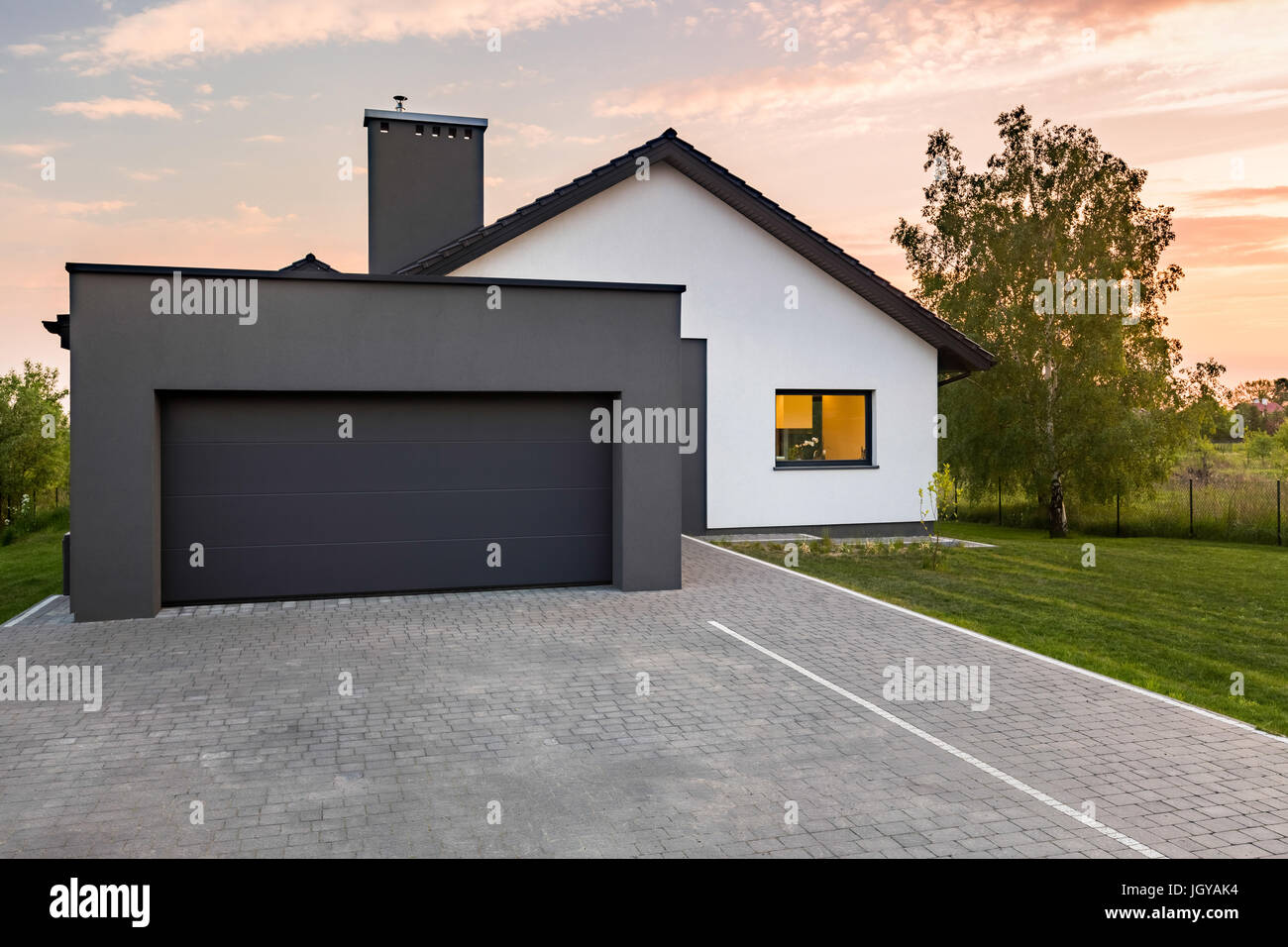 Stylish house with garage and cobblestone driveway, outdoors Stock Photo