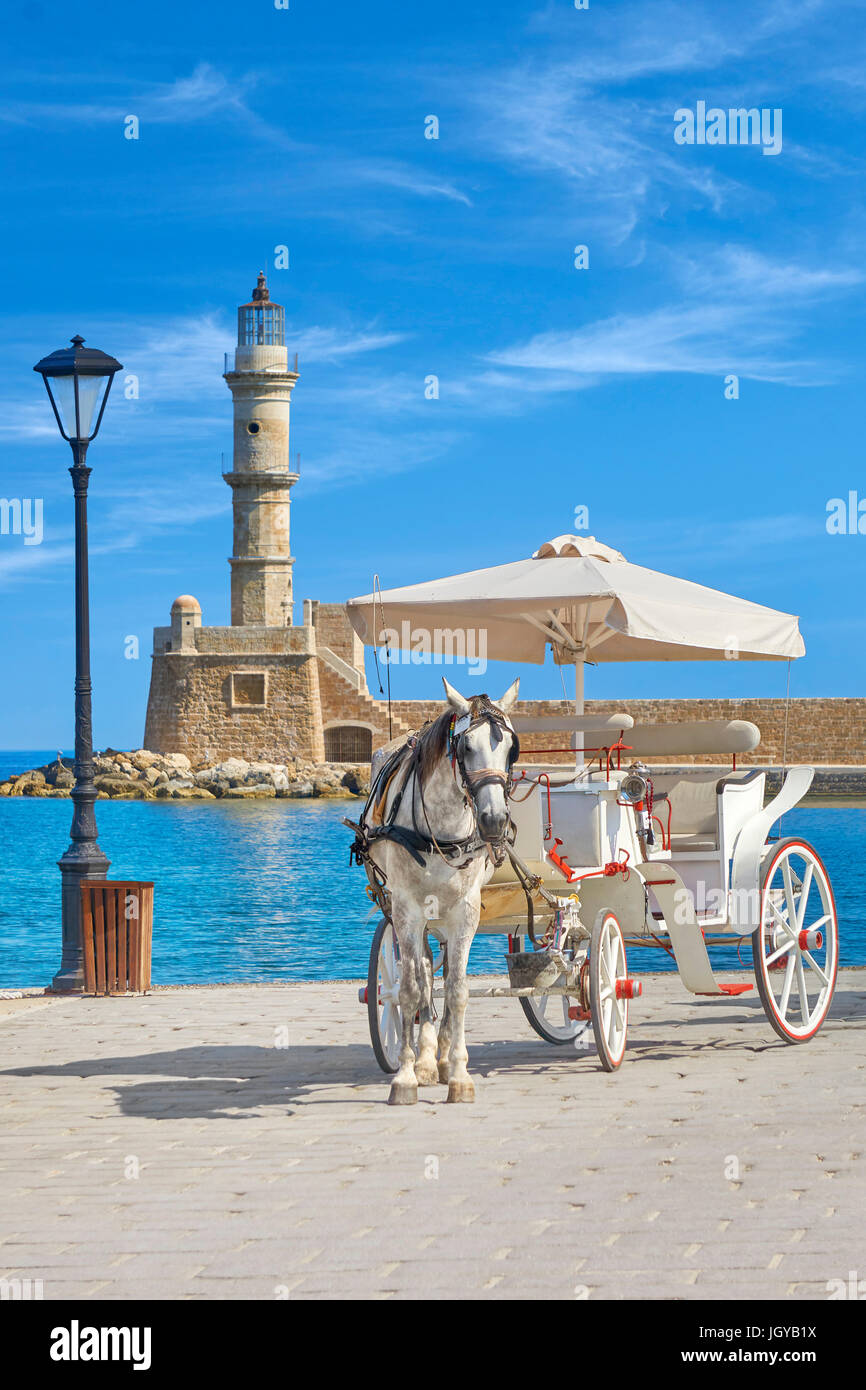 Carriage with horse on the Venetian Harbour, lighthouse in the background, Chania, Crete Island, Greece Stock Photo