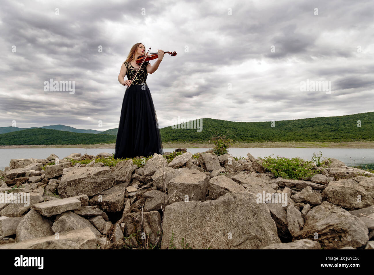 Beautiful female viola player on the lake shore Stock Photo Alamy