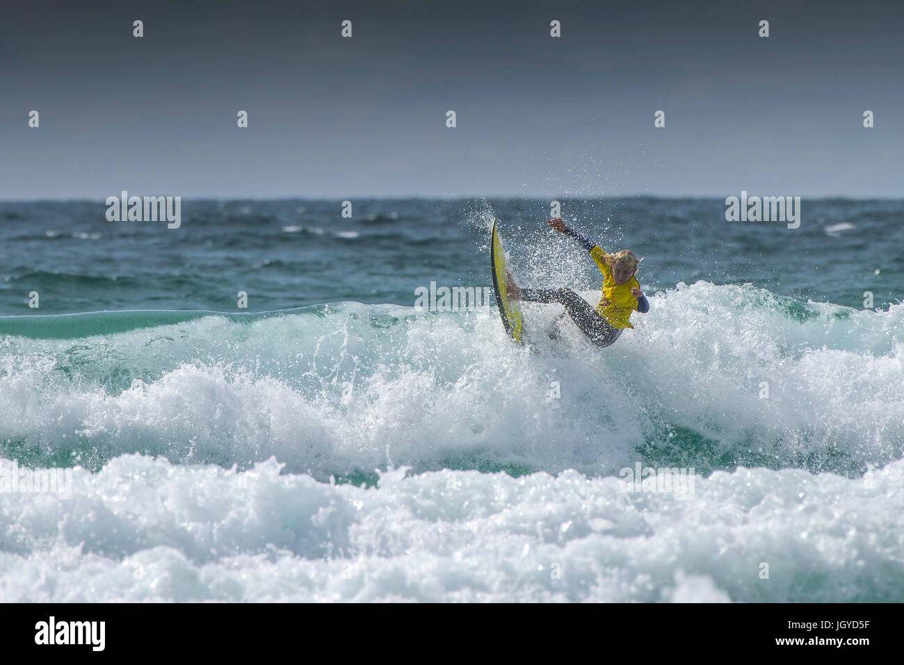 Surfing UK. A young male surfer competing in the UK Schools Surf Championship.; Nerf Clash of the Groms at Fistral in Newquay; Cornwall. Stock Photo