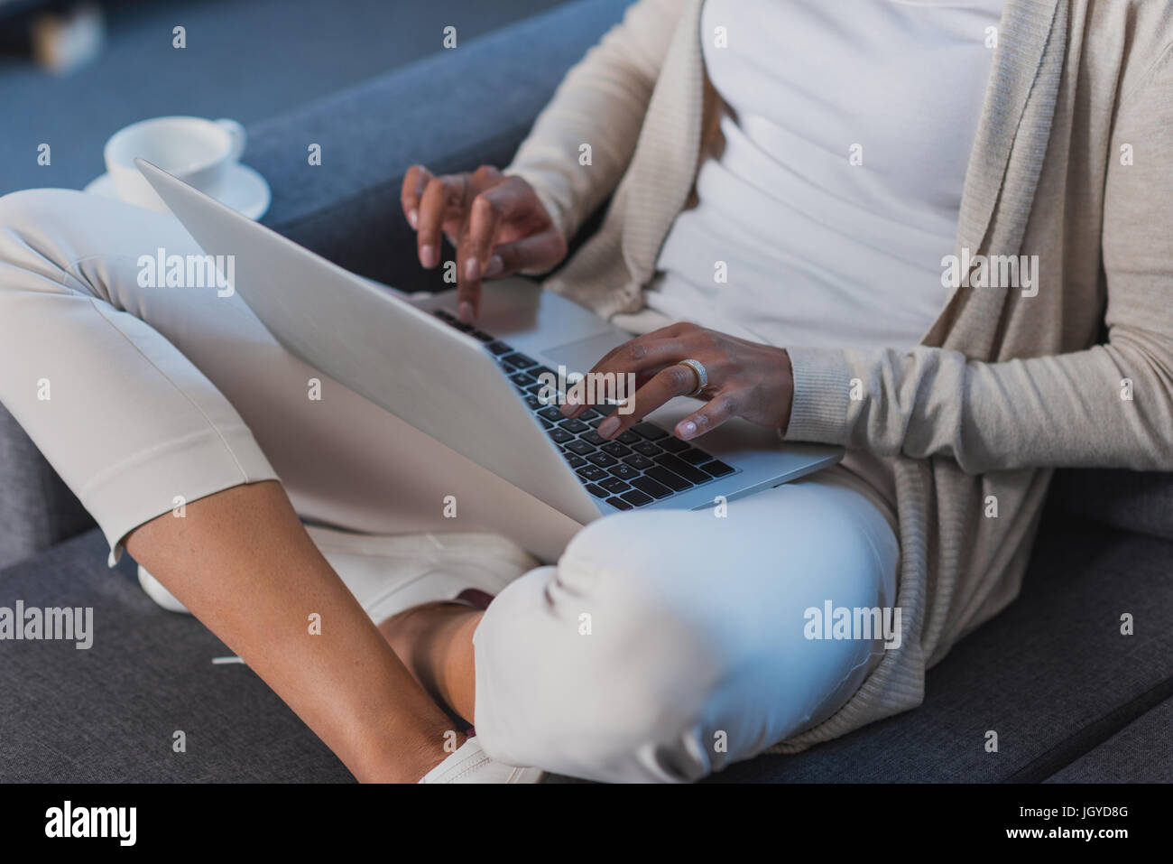 young woman using laptop while sitting on sofa at home Stock Photo - Alamy