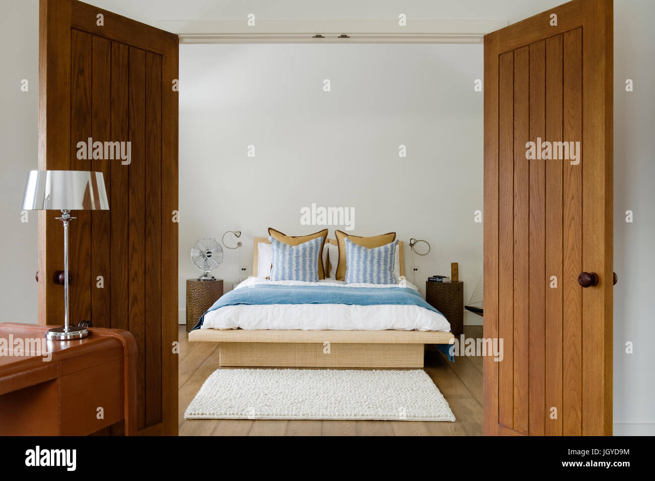 Open wooden doors to coastal bedroom Stock Photo