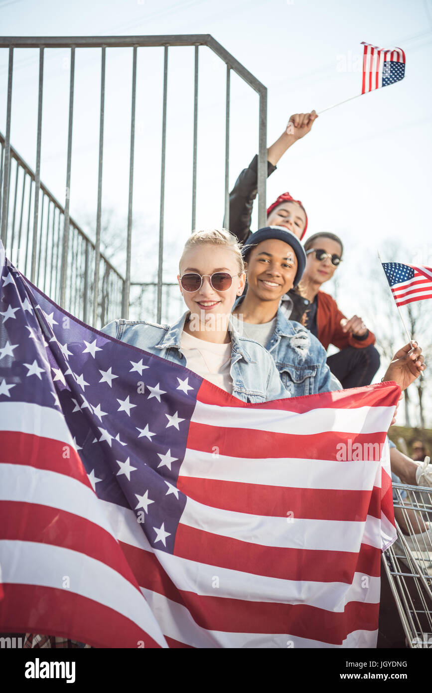 Happy teenagers group having fun and waving american flags at sunset Stock Photo