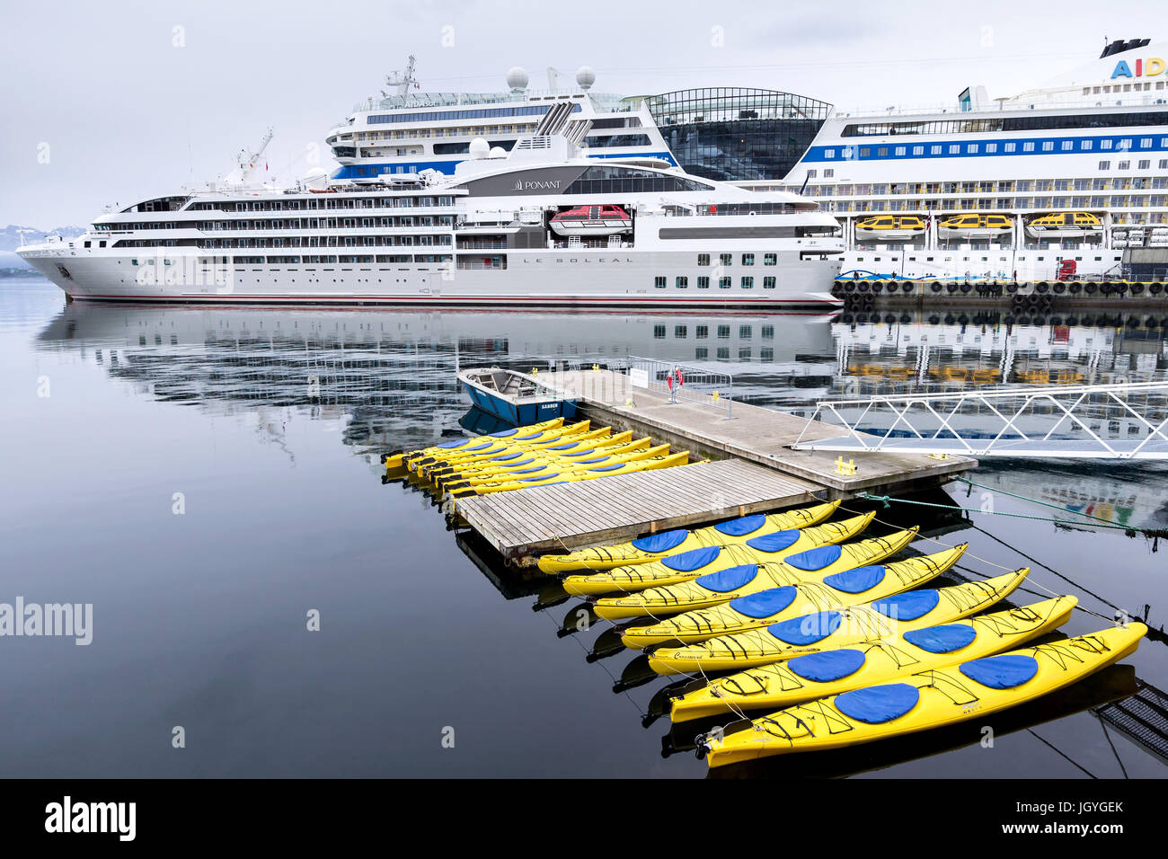 Cruise ships and kayaks in Alesund. Alesund is noted for its concentration of Art Nouveau architecture and therefore a popular cruise destination. Stock Photo