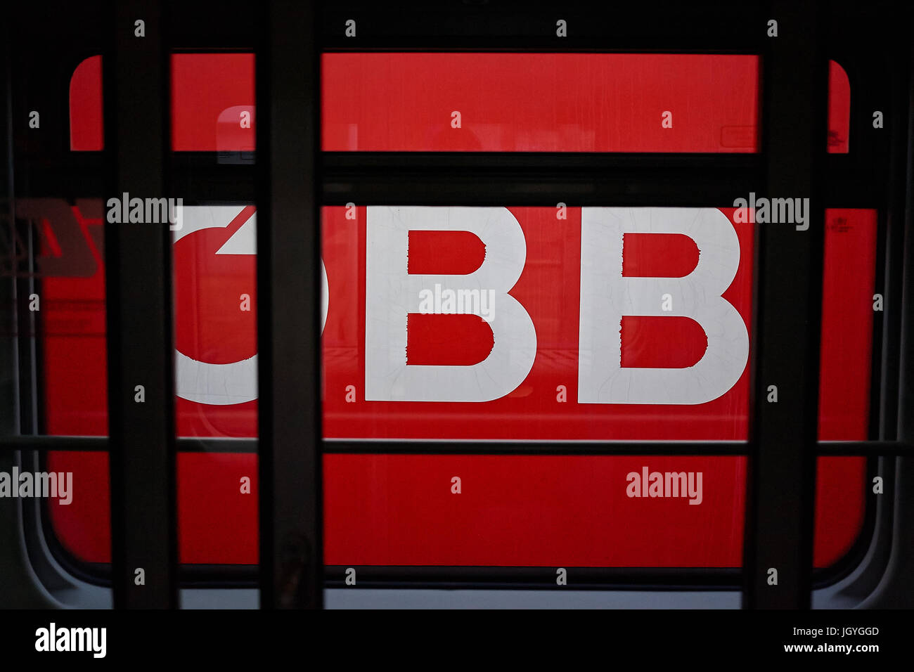 OBB, the logo of the Austrian Federal Railways, on the side of a train seen from another train. Stock Photo