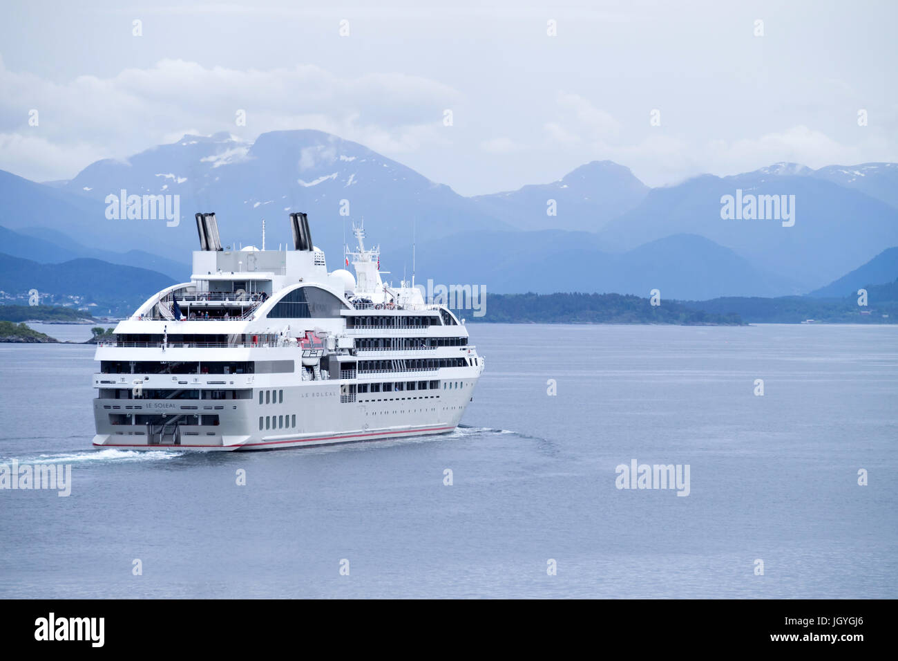 French cruise ship LE SOLEAL outbound Alesund. LE SOLEAL has 132 cabins and suites for 264 passengers and is owned and operated by Compagnie du Ponant Stock Photo