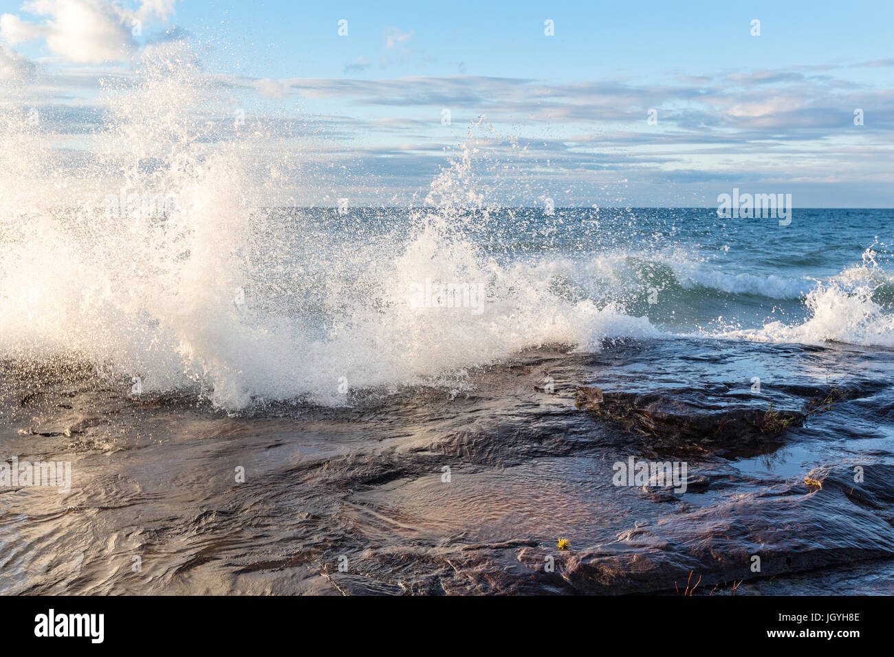 Lake Superior gale force winds drive a crashing wave over sandstone rock at Pictured Rocks National Lakeshore in Munising Michigan Stock Photo
