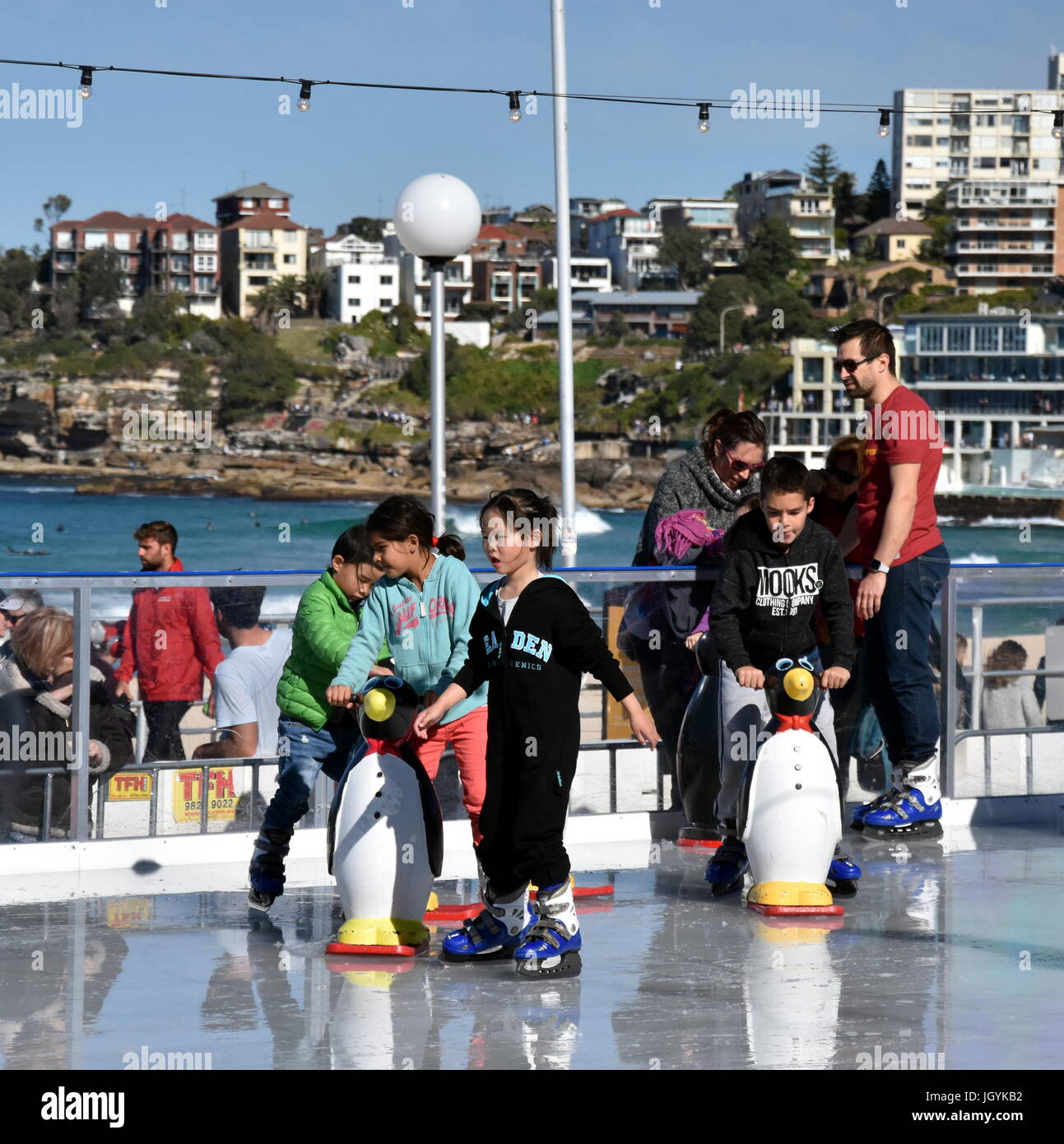Sydney, Australia Jul 9,, 2017. Kids and parents ice skating with a Penguin Skate Aid on Bondi