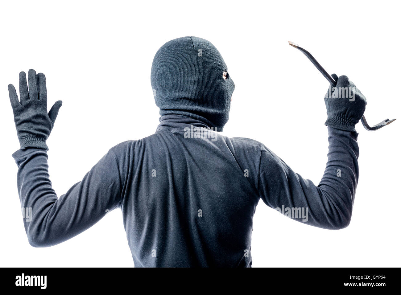 View from the back of a criminal in a balaclava with his hands raised on a white background Stock Photo