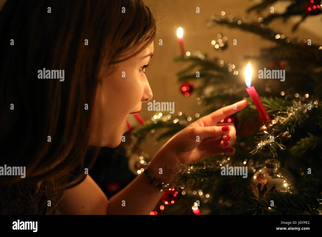 Christmas tree. Young girl and candle.  Geneva. Switzerland. Stock Photo