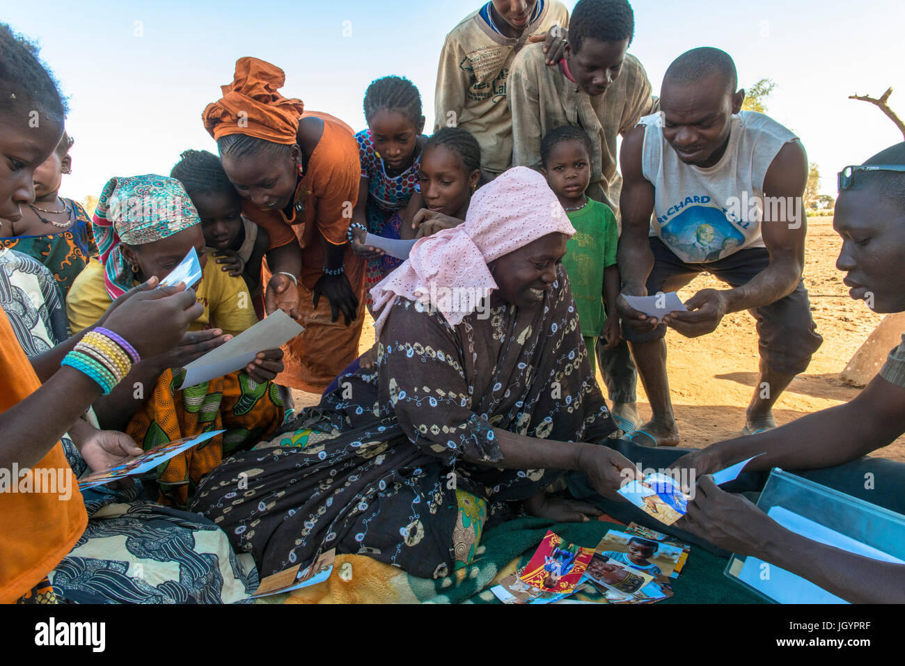 African villagers looking at photographs of themselves. Senegal. Stock Photo