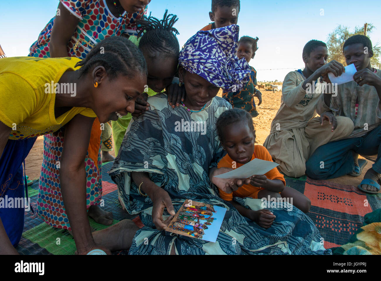 African villagers looking at photographs of themselves. Senegal. Stock Photo