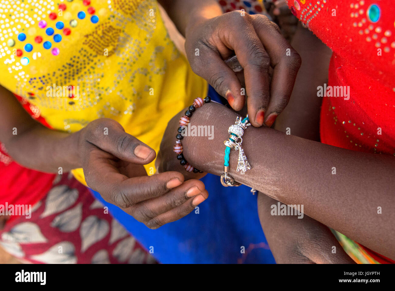Girls fastening a bracelet. Senegal. Stock Photo