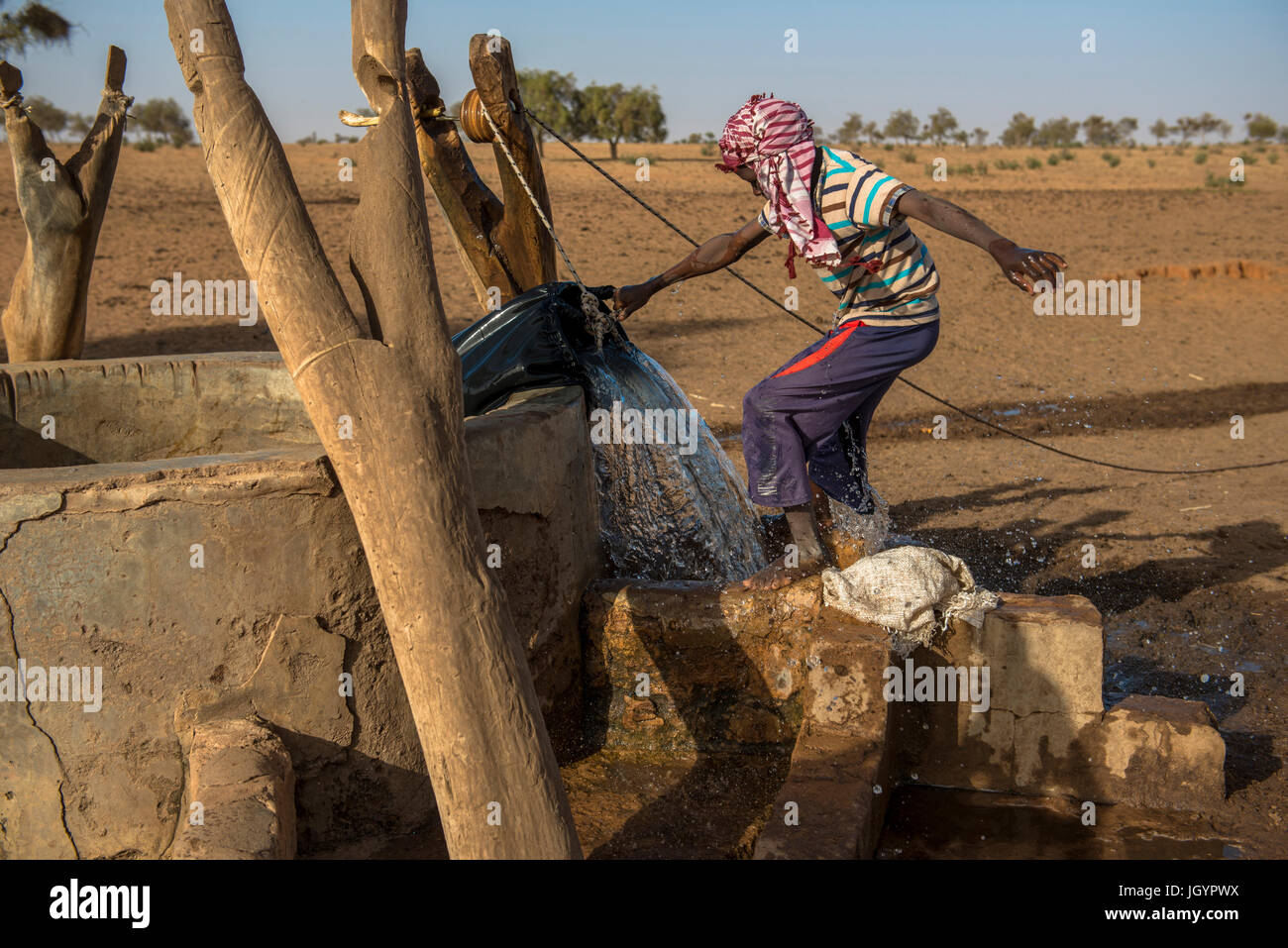 Peul boy fetching water from a well. Senegal. Stock Photo