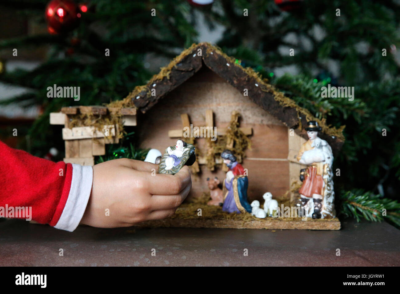 10-year-old boy laying a Christmas nativity scene. France. Stock Photo