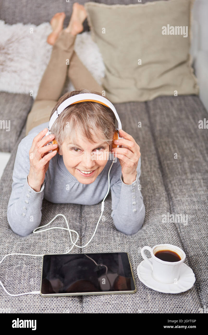 Senior woman listening to ebook for leisure and relaxation Stock Photo