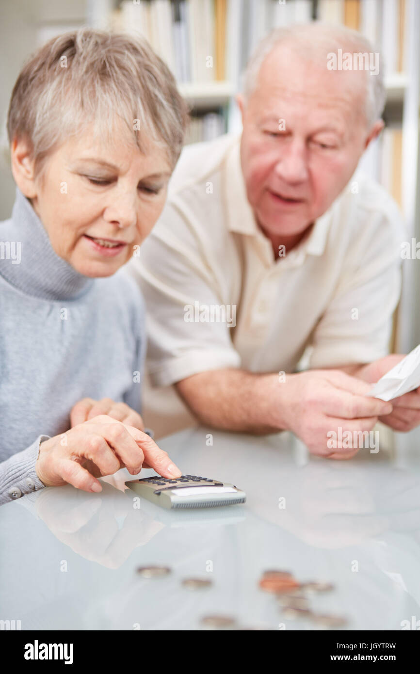 Retiree and pensioner couple doing accounting with calculator Stock Photo