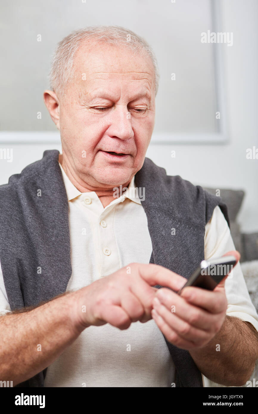 Senior typing message on smartphone as modern man Stock Photo