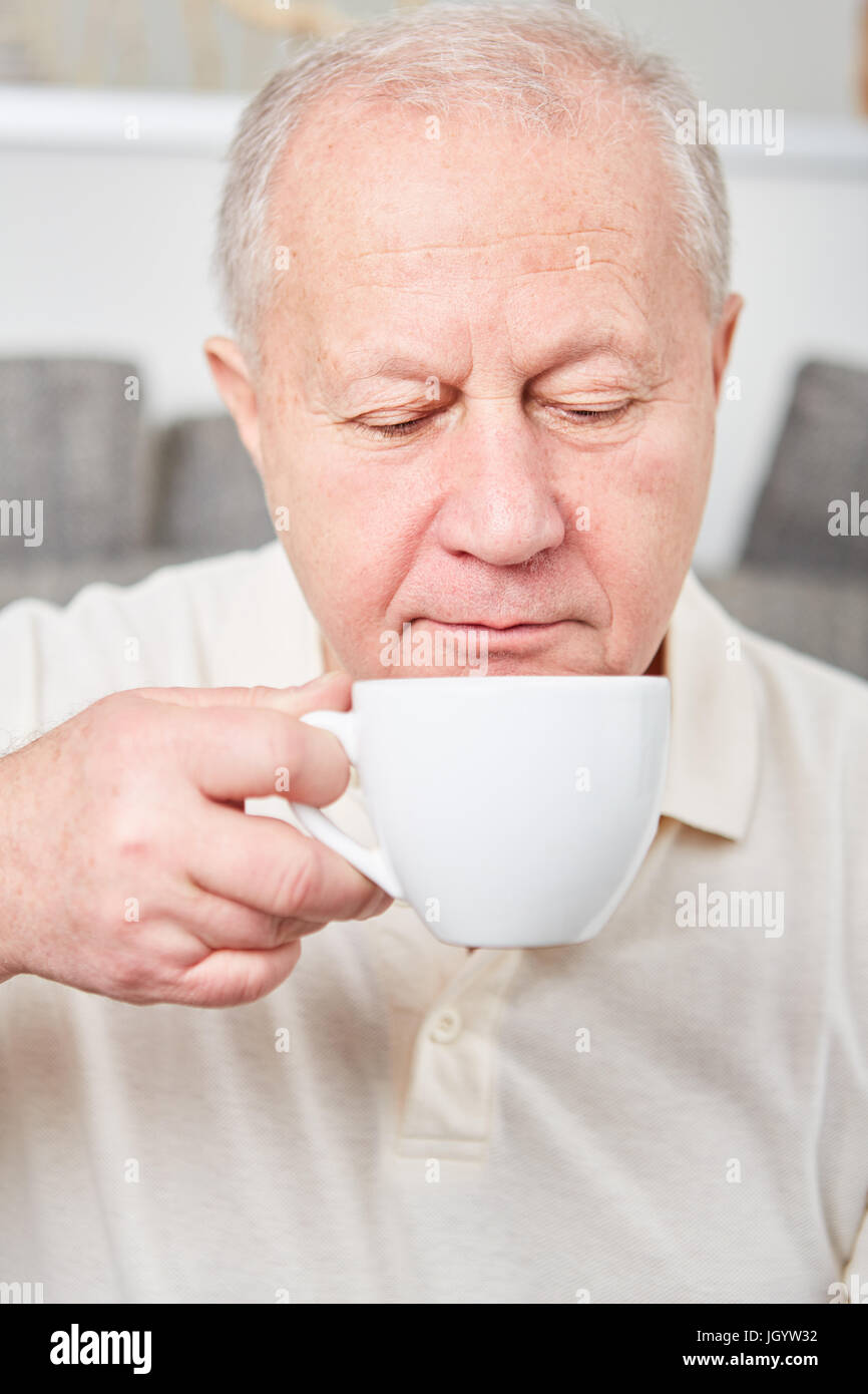 Senior drinks cup of coffee and takes a relaxation break Stock Photo