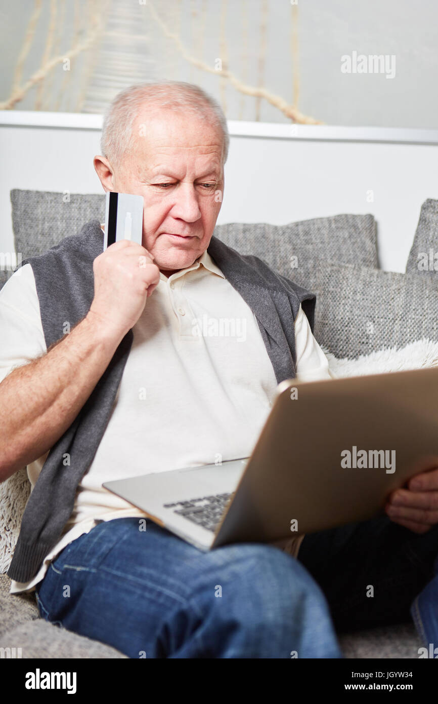 Senior with laptop making a decision about online shopping Stock Photo