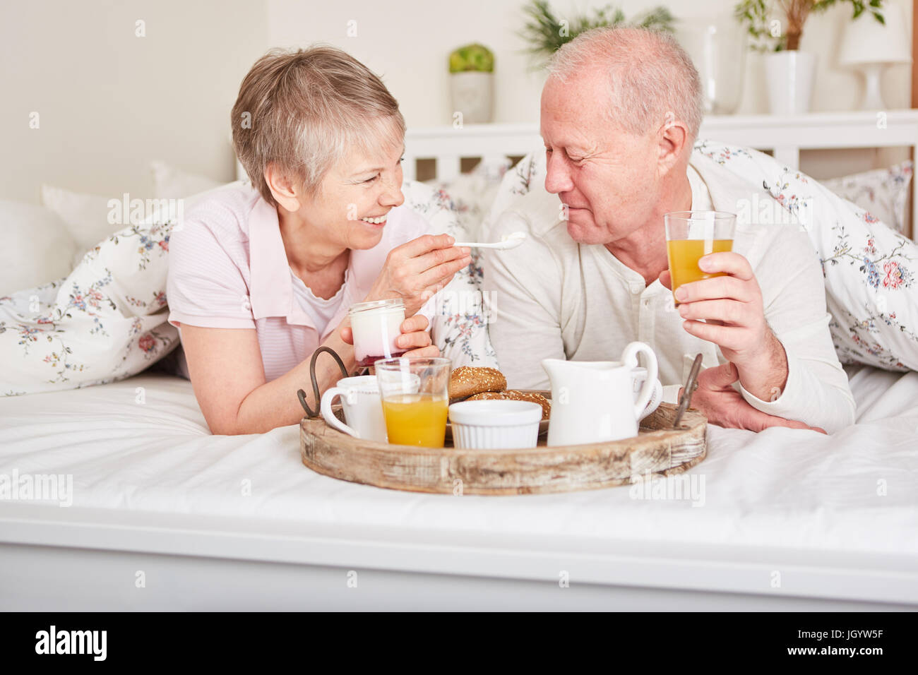 Senior couple in love having breakfast in their hotel room during their holiday vacation Stock Photo