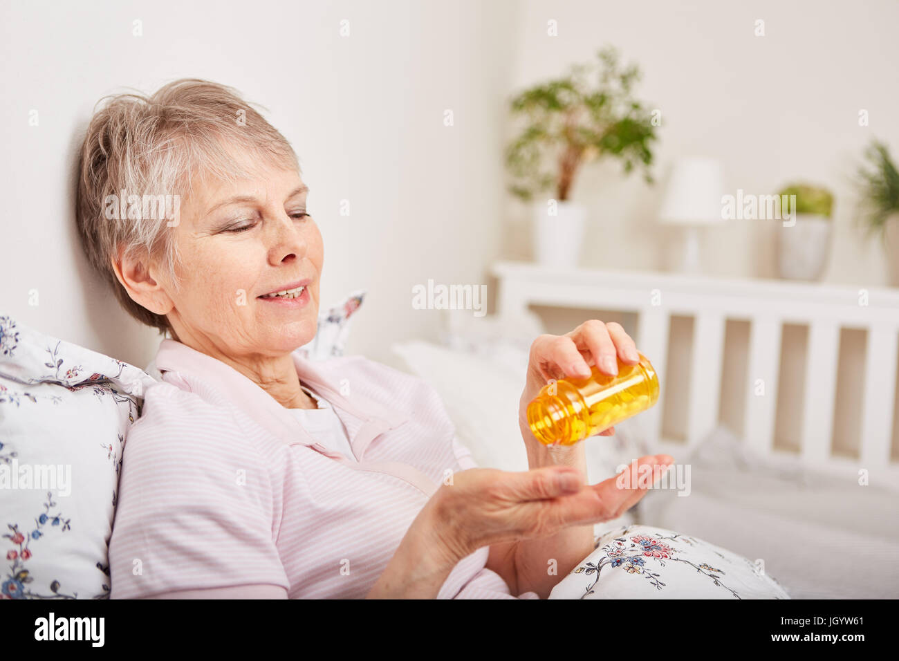 Old sick or ill senior woman taking medicine for therapy Stock Photo