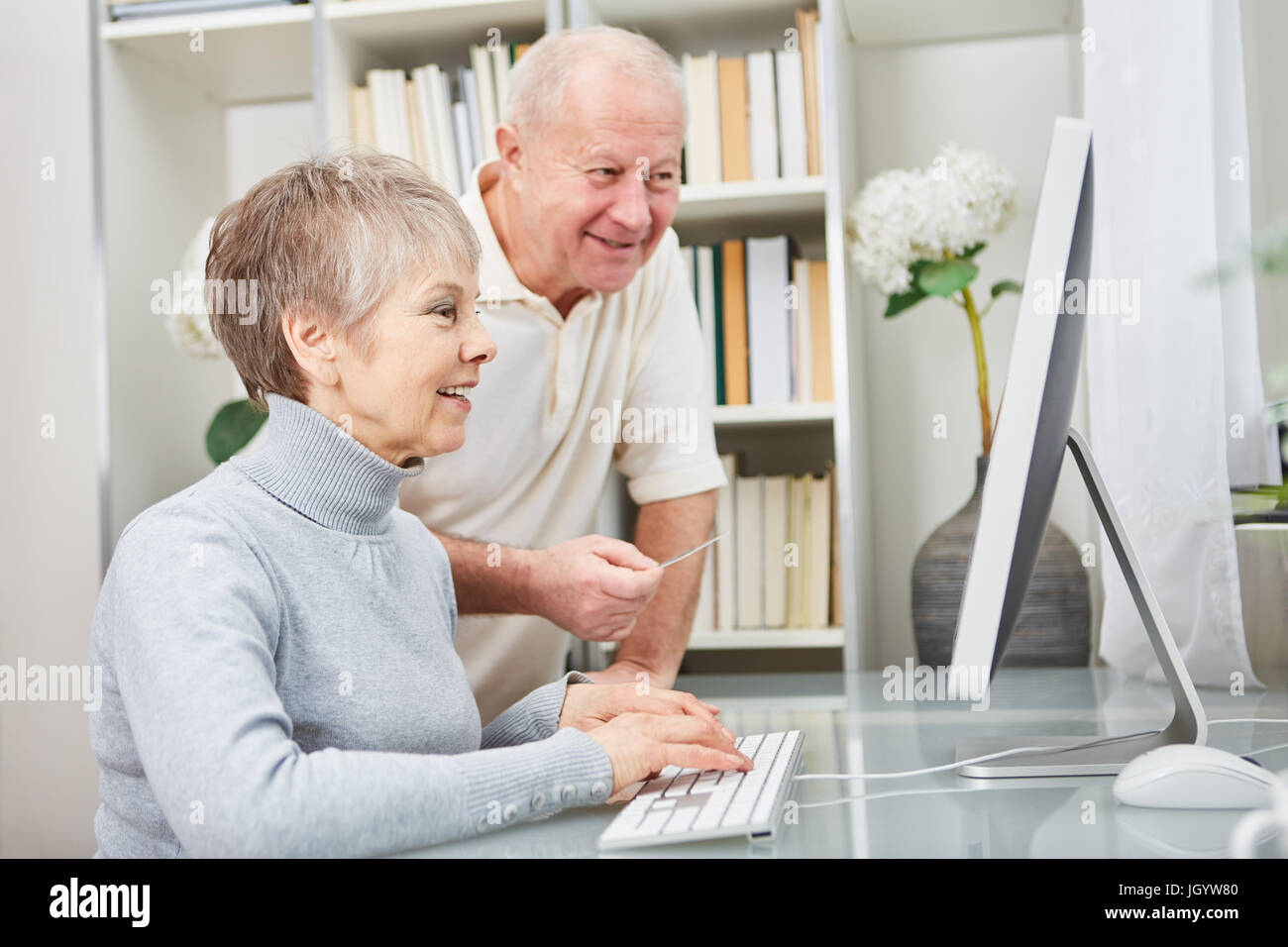 Senior couple learn about computers and look monitor with curiosity ...