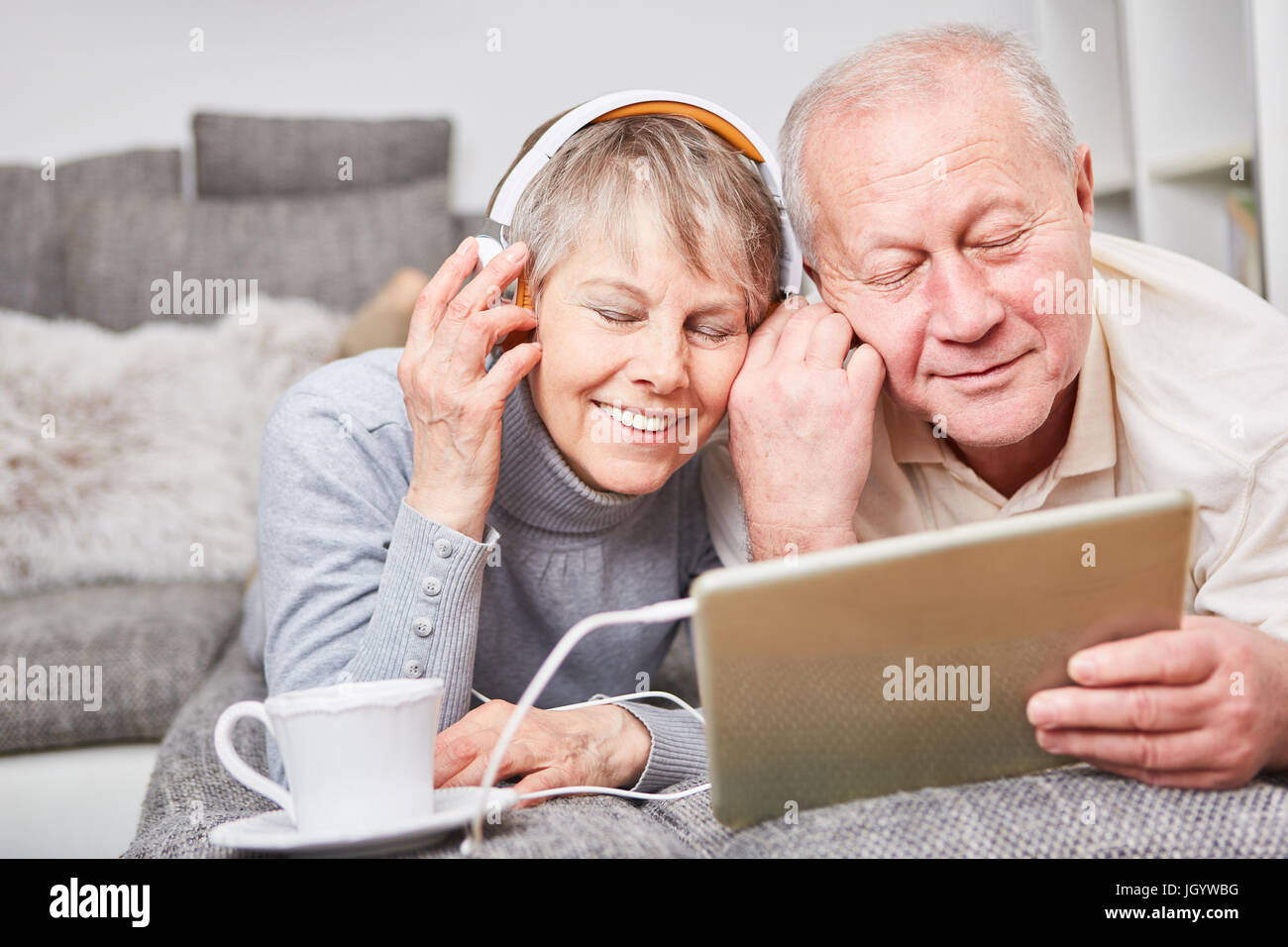 Seniors listen to music with enjoyment for relaxation on couch Stock Photo