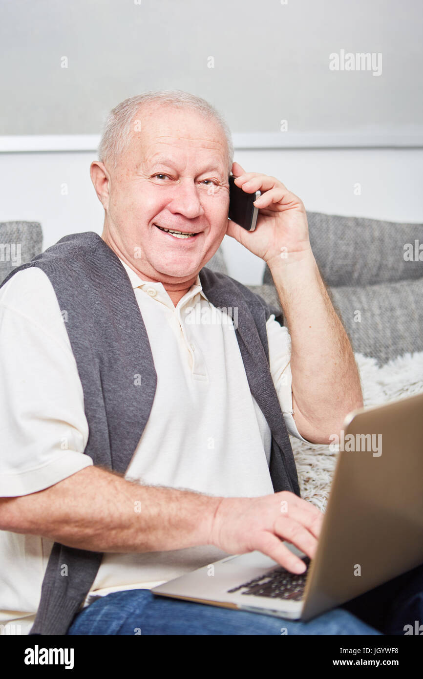 Senior as retiree or pensioner calling with a smartphone Stock Photo