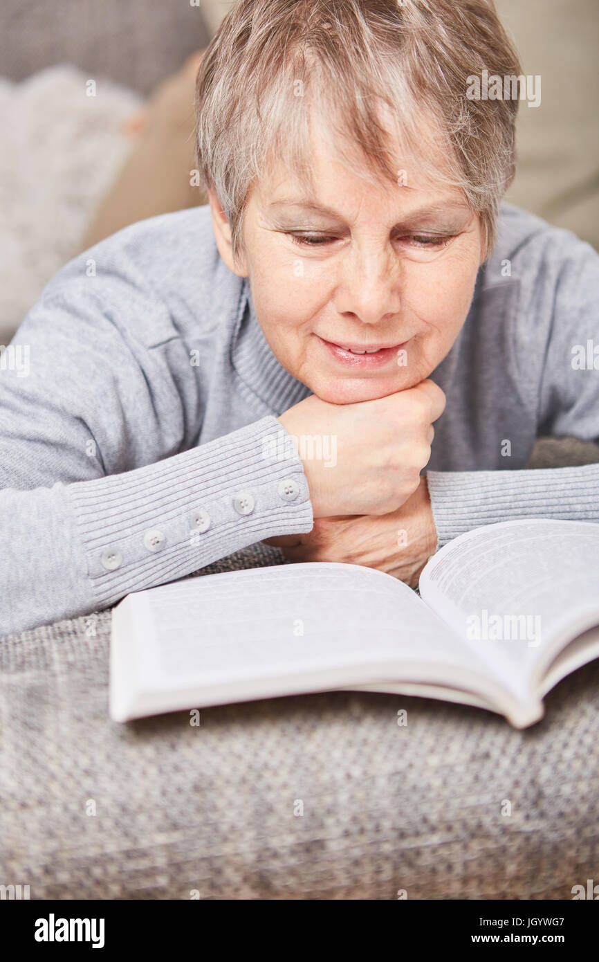Senior reads book for relaxation and entertainment Stock Photo
