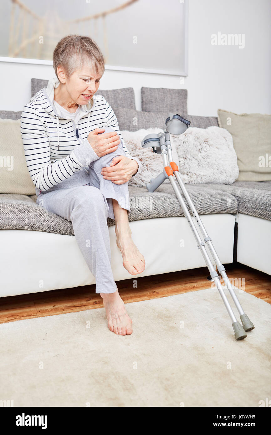Senior woman with crutches has pain on knee Stock Photo Alamy
