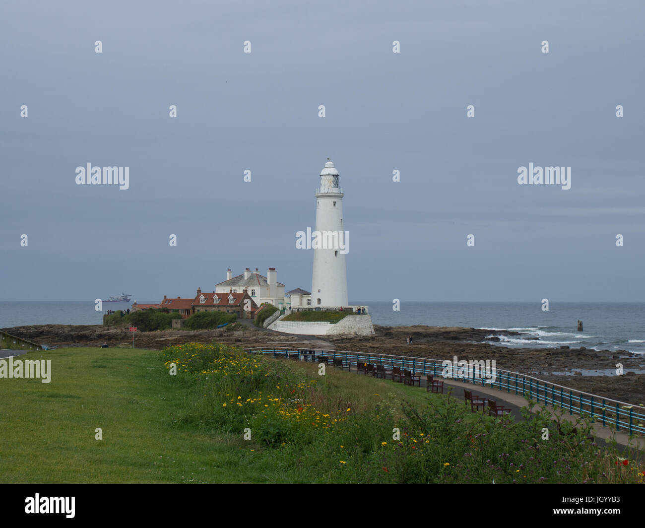 St. Mary's Island Lighthouse, Whitley Bay, Northumberland, tide going out, a ship in the distance Stock Photo