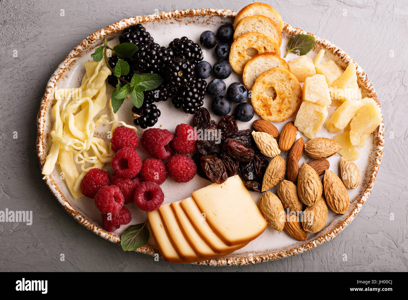 Cheese plate with nuts and berries Stock Photo