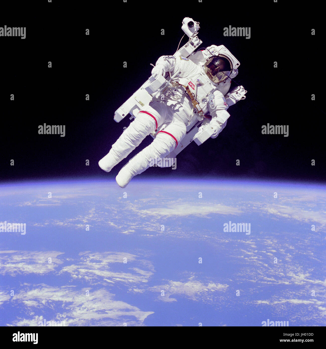 'Backpacking'.Full Description.Mission Specialist Bruce McCandless II ventured further away from the confines and safety of his ship than any previous astronaut ever has. This space first was made possible by the Manned Manuevering Unit or MMU, a nitrogen jet propelled backpack. After a series of test maneuvers inside and above Challenger's payload bay, McCandless went 'free-flying' to a distance of 320 feet away from the Orbiter. The MMU is controled by joy sticks positioned at the end of the arm rests. Moving the joy sticks left or right or by pulling them fires nitrogen jet thrusters propel Stock Photo