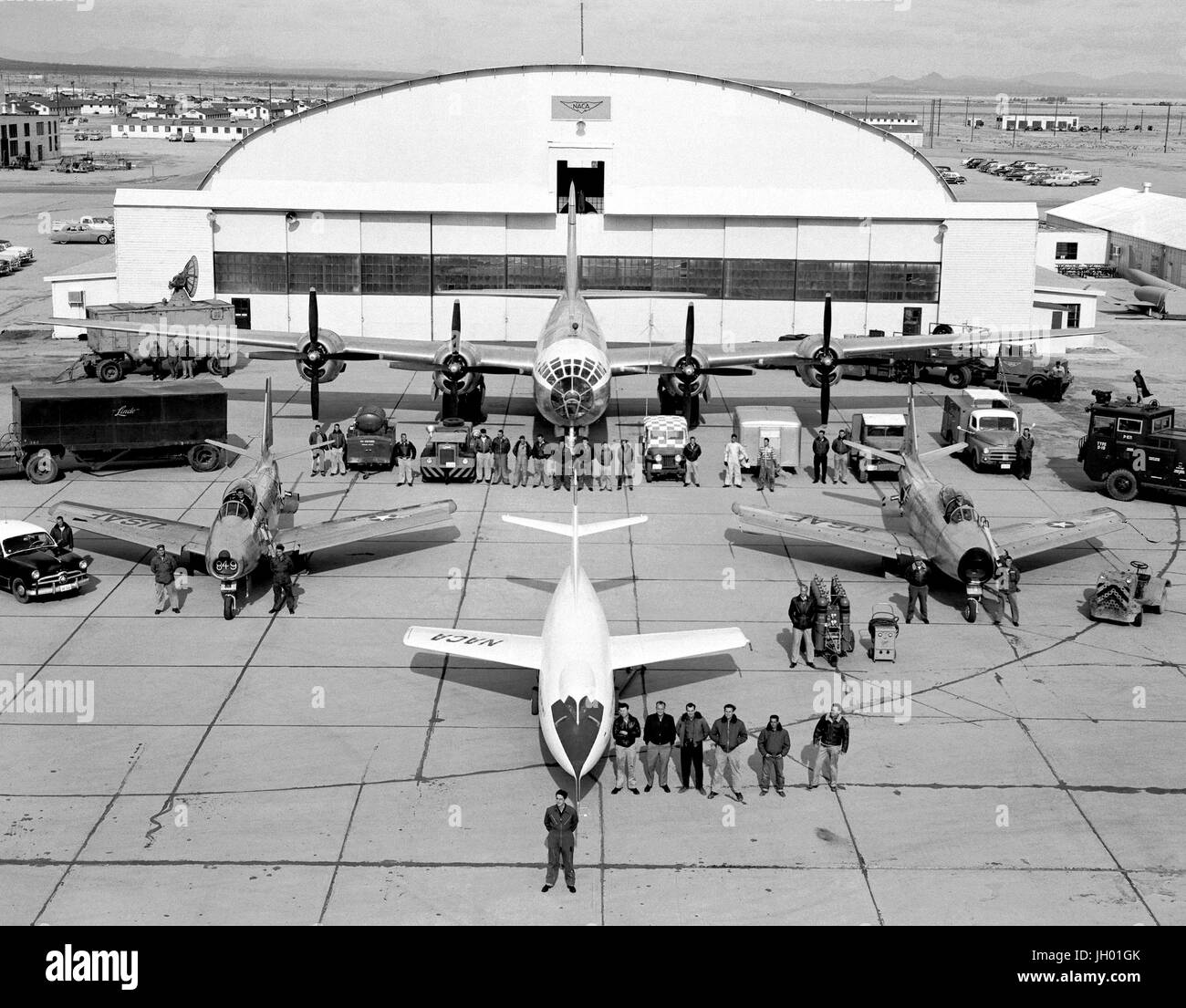 The fleet of NACA test aircraft are assembled in front of the hangar at the High Speed Flight Station, (later renamed the Dryden Flight Research Center) in Edwards, California. The white aircraft in the foreground is a Douglas Aircraft D-558-2 Skyrocket. To its left and right are North American F-86 Sabre chase aircraft. Directly behind the D-558-2 is the P2B-1 Superfortress, (the Navy version of the Air Force B-29). Also known as the 'mothership,' the P2B-1 carried aloft the D-558-2 Skyrocket under its fuselage. Once reaching altitude, the D-558-2 was released from the 'mothership' . Stock Photo